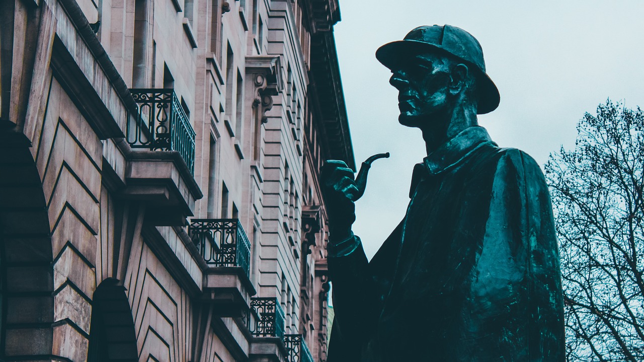 Estatua de Sherlock Holmes con su característica pipa frente a un edificio de estilo victoriano en Londres.