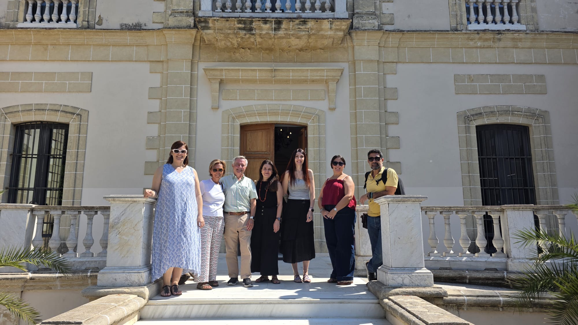 Participantes en la visita de la Sociedad Literaria Sherlock Holmes posan ante la entrada del Palacio del Tiempo de Jerez.